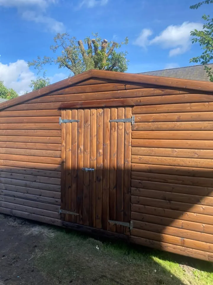 Large stained timber garden building with double doors
