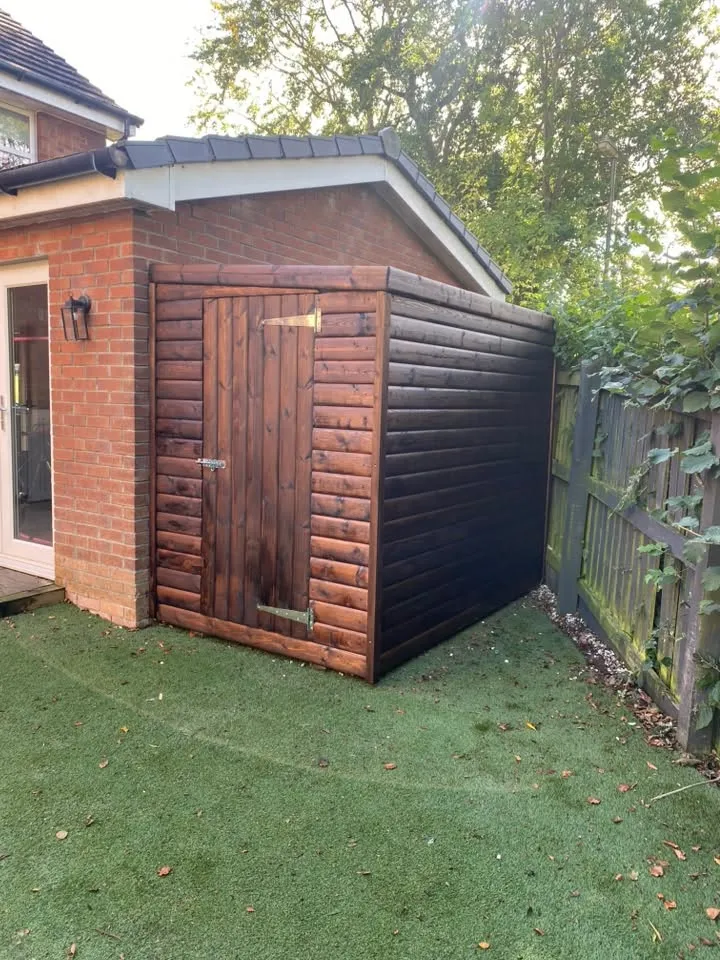 Dark-stained timber storage building
